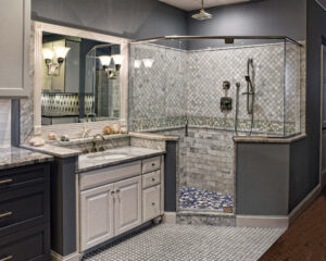 Modern bathroom with glass-enclosed shower, white vanity, marble accents, and wall-mounted light fixtures.
