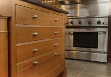 Wooden cabinets in kitchen with silver oven